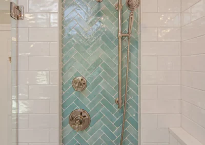 Tile inset behind showerhead inside a custom shower renovation by Oak Ridge Builders