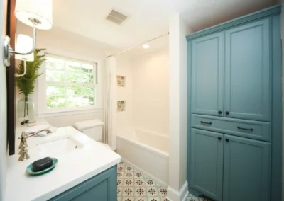 Custom renovated bathroom with blue cabinetry and a fun accent tile on the floor