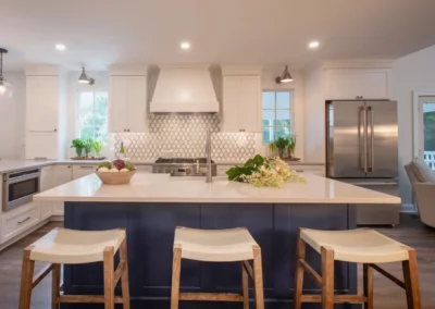 Renovated kitchen with white cabinets and a large island painted blue