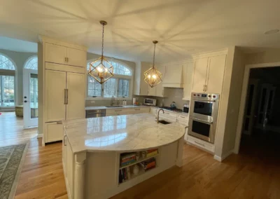 A renovated kitchen with a large island with storage and sink inside the island