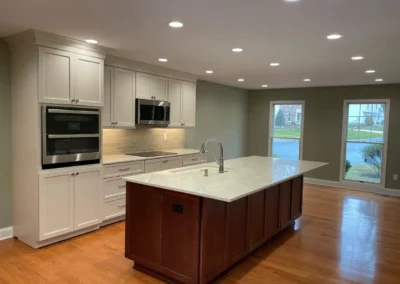 Renovated kitchen with white cabinetry and a natural wood island